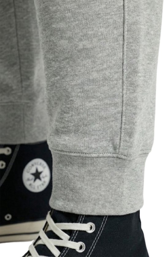 Detail van de onderkant van een lichtgrijze joggingbroek met elastische boord.