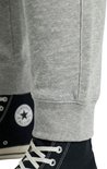Detail van de onderkant van een lichtgrijze joggingbroek met elastische boord.