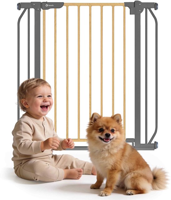 Baby en hond voor een hekje met houten spijlen en donkergrijs frame.