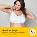 Une femme enceinte souriante porte un soutien-gorge d'allaitement blanc sans couture et sans armatures.