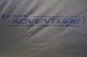 Khaki stof met 'Ultimate Adventure Dome 1-Man bivvy' logo in blauw.