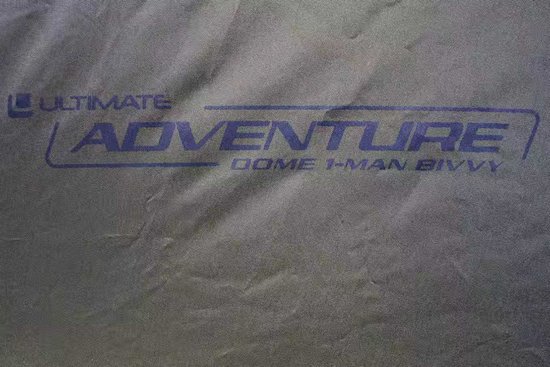 Khaki stof met 'Ultimate Adventure Dome 1-Man bivvy' logo in blauw.
