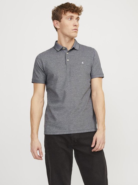 Man met kort bruin haar draagt een grijs gemêleerd poloshirt met korte mouwen en Jack & Jones logo.