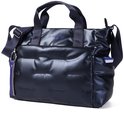 Zijaanzicht van de donkerblauwe, glanzende, gewatteerde tas met handvatten en schouderband.