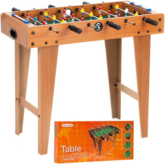Voetbaltafel van hout met groen veld, kleine spelers in rode en gele tenues, met verpakking.