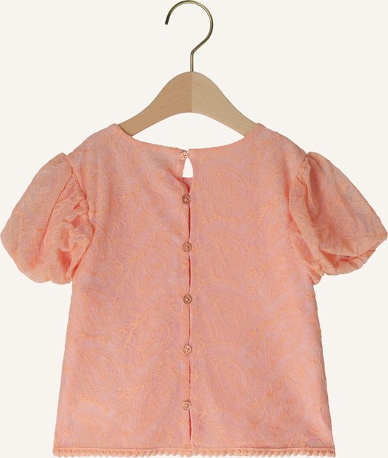 Achterkant van een perzikkleurige blouse met kanten textuur, korte pofmouwen en knoopsluiting.