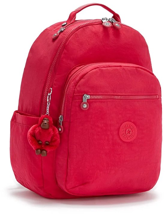 Sac à dos Kipling rouge avec porte-clés singe rouge, une poche avant zippée et des poches latérales.