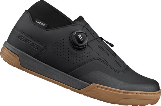 Een zwarte Shimano fietsschoen met bruine zool, BOA-sluiting en perforaties. De schoen heeft de letters GFZ op de zijkant.