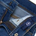 Detail van de tailleband van een blauwe skinny jeans, met rits, knoop en verstelbare elastiek.