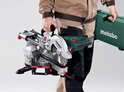 Man met Metabo afkortzaag en groene koffer.