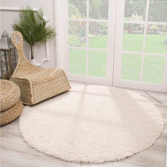Rond crème shaggy vloerkleed met een zachte, hoogpolige textuur. 120 cm doorsnee.