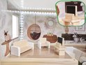 Poppenhuis woonkamer met bank, stoel, bijzettafel en een mini-krijtbord. Behang met planten.