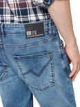 Close-up van de achterkant van een lichtblauwe jeans met een zwart label "TTD TOM TAILOR DENIM BRAND".