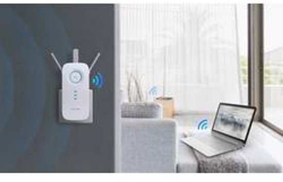 Witte TP-Link wifi-repeater, in een woonkamer, aangesloten op een stopcontact nabij een bank.