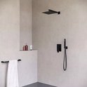 Doucheset in een moderne badkamer met matzwarte douchekop, handdouche, inbouw kraan en badkameraccessoires.