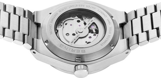 Achterkant van zilverkleurig horloge met zichtbaar automatisch uurwerk en tekst: BERING, STAINLESS STEEL, SAPPHIRE CRYSTAL, WATER RESISTANT 10 ATM, 19441-CHARITY.