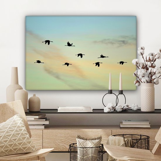 Tableau sur toile Un ciel bleu-jaune avec huit grues - 90x60 cm - Décoration murale