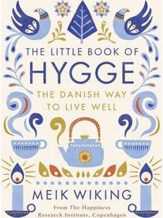 De voorkant van het boek "The Little Book of Hygge" met een illustratie van een blauwe theepot, twee kopjes, kaarsen en vogels. De titel is in grote letters geschreven.