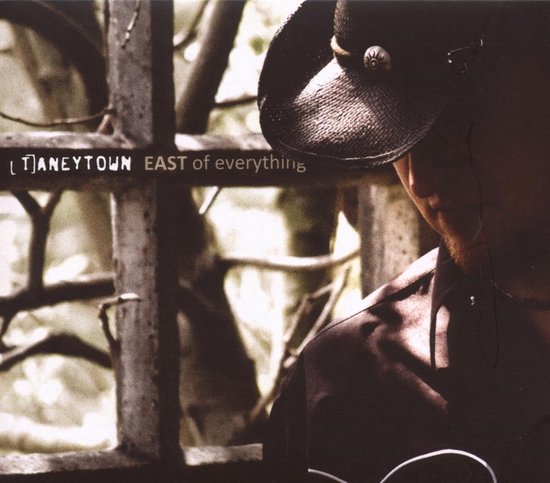 Cover van "EAST of everything" met een man met een cowboyhoed.