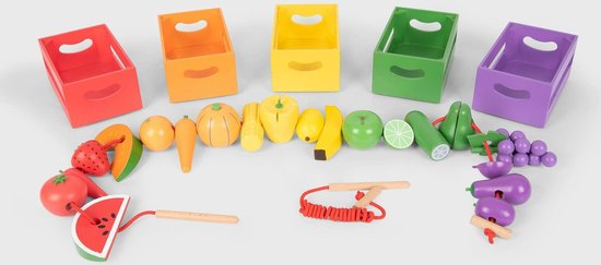 Jouets en fruits et légumes en bois, disposés à côté de caisses de tri colorées.