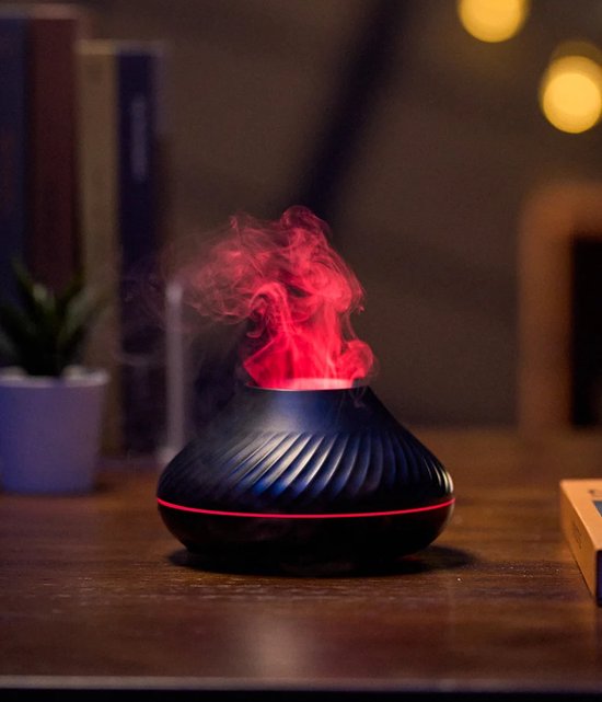 Zwarte aroma diffuser met ribbels, op een bureau, met rode vlamvormige nevel.