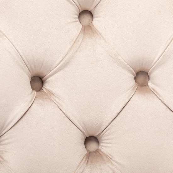 Detail van de knopen-quilting op een beige fluwelen eetkamerstoel.