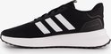 Zwarte Adidas sneaker met witte strepen en witte zool.