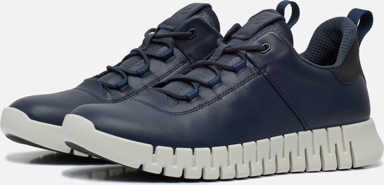 Paire de sneakers ECCO bleu marine avec semelles blanches dentelées, lacets et boucles à l'arrière.