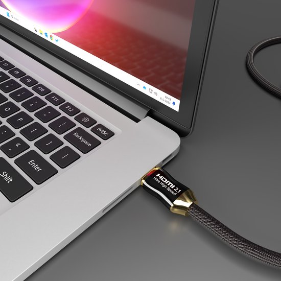 Zwarte HDMI 2.1 kabel met gouden accenten aangesloten op een laptop.