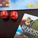 Twee rode dobbelstenen met de cijfers 3 en 5 naast een kaart van "Rovers van de Noordzee".
