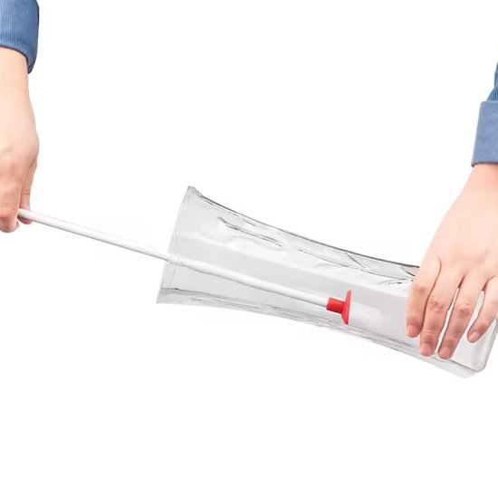 Handen gebruiken een witte flessenschraper met rood uiteinde om een glazen pot schoon te maken.