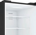 Leeg interieur van een zwarte Inventum koel-vriescombinatie met twee glazen planken.