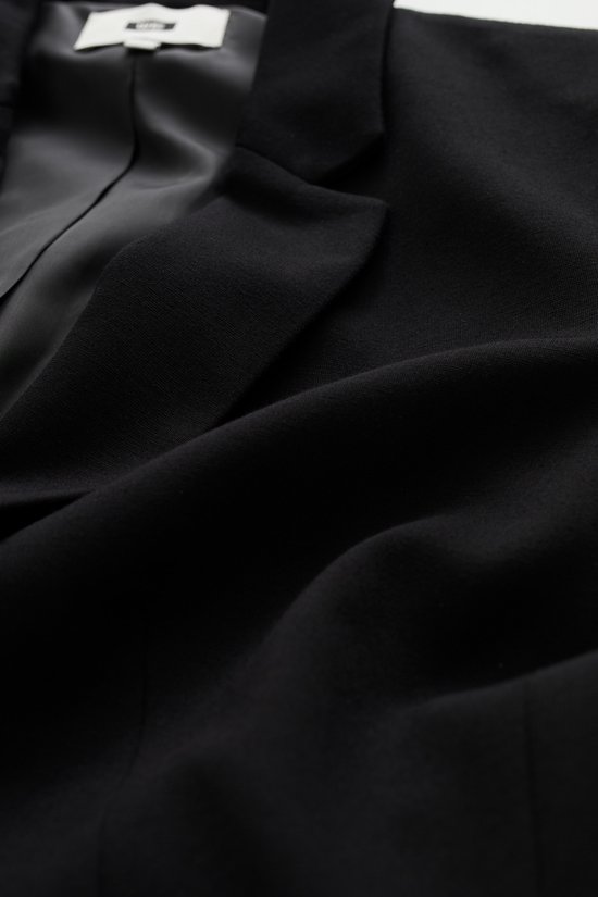 Close-up van de zwarte binnenvoering en stof van een blazer.