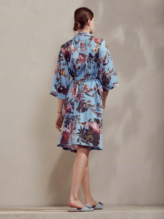 Model, achteraanzicht, in blauwe kimono met bloemenprint en tailleband.