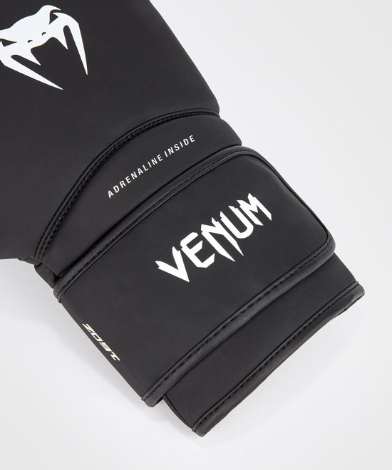Detail van een zwarte Venum bokshandschoen met witte opdruk.