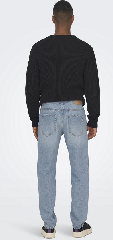 Man in een zwarte gebreide trui en lichtblauwe jeans, zicht van achteren.