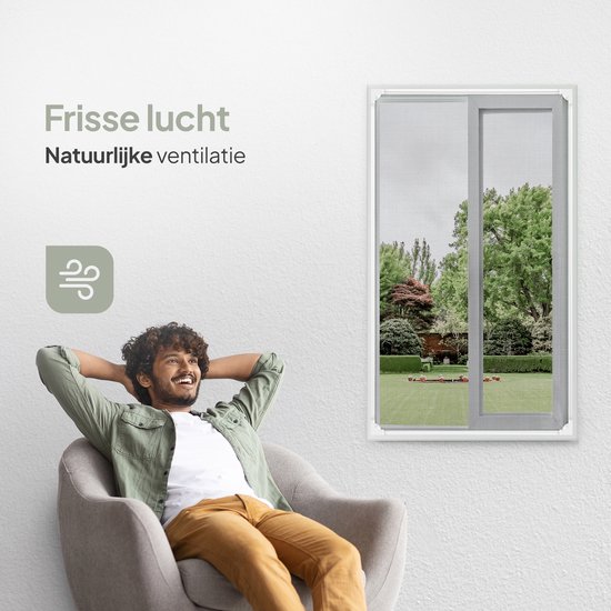 Man ontspant zich in een stoel bij een raam met een magnetische hor, genietend van frisse lucht.