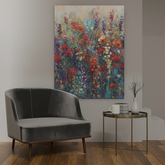 Une grande peinture de fleurs rouges et violettes dans un champ, au-dessus d'un fauteuil gris.