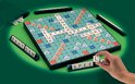 Scrabble XL spel met groene achtergrond. Hand plaatst een tegel op het bord.