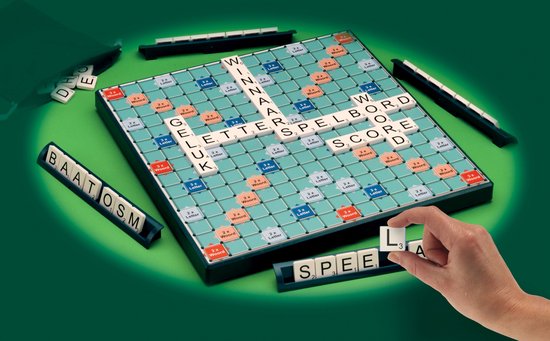 Scrabble XL spel met groene achtergrond. Hand plaatst een tegel op het bord.