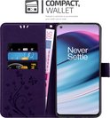 Étui de téléphone violet avec fentes pour cartes, carte de crédit et billet de 500 euros, et un téléphone avec le texte 'Never Settle'.