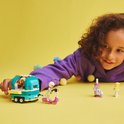 Kind met LEGO Friends mobiele bubbelthee stand, scooter en blender op een gele ondergrond.