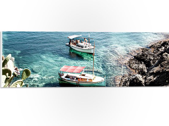 WallClassics - PVC Schuimplaat- Overdekte Vissersbootjes bij Rotsen in Blauwe Zee - 60x20 cm Foto op PVC Schuimplaat