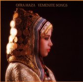 Ofra Haza in traditionele kledij met gouden, beige en blauwe hoofdtooi, versierd met munten.
