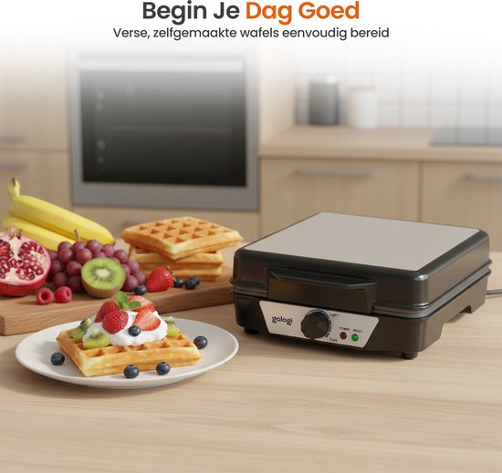Een zwarte wafelmaker op een houten aanrecht, met een bord met een wafel versierd met slagroom en fruit ernaast. Op de achtergrond staan bananen, druiven en kiwi.