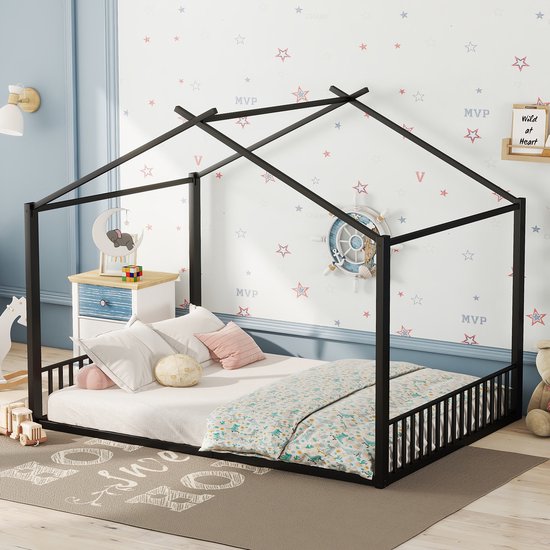 Zwart huisvormig bedframe met dakconstructie, versierd met beddengoed, kussens en kinderspeelgoed.