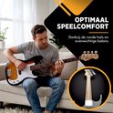 Man zit op een bank en speelt op een sunburst basgitaar met een ronde hals.