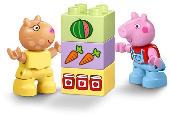 Peppa Pig en Suzy Schaap LEGO Duplo figuren staan naast gestapelde bouwstenen met watermeloen, wortels en potjes jam.