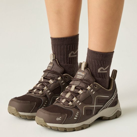 Voeten in bruine sokken met R-logo, en bruine wandelschoenen met veter en witte accenten.