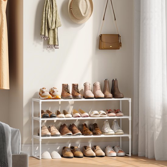 Wit schoenenrek met drie lagen, gevuld met diverse schoenen, laarzen, een tas en een hoed.